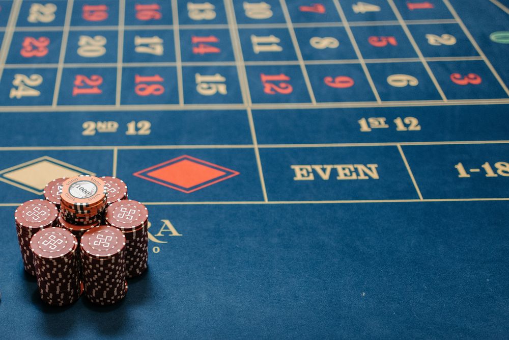 Meja roulette dengan roda dan tumpukan chip kasino